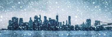 Manhattan'ın siluetleri. Brooklyn Köprüsü ile erken sabah New York City skyline panorama bir kar yağışı sırasında