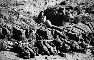 Plajda çıplak kız tans. Genç çıplak kadın kil cliff sahil üzerinde yatıyor. Siyah beyaz resim