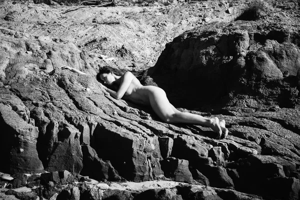 Plajda çıplak kız tans. Genç çıplak kadın kil cliff sahil üzerinde yatıyor. Siyah beyaz resim