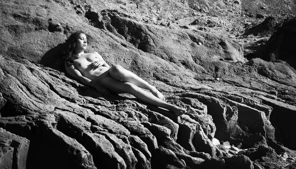 Plajda çıplak kız tans. Genç çıplak kadın kil cliff sahil üzerinde yatıyor. Siyah beyaz resim