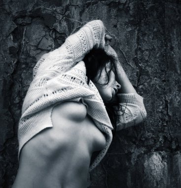 Yaşam tarzı kavramı. Koyu mavi makamı tek renkli görüntüde. Eski beton duvar arka plan karşı bir ceket ile çıplak kadın