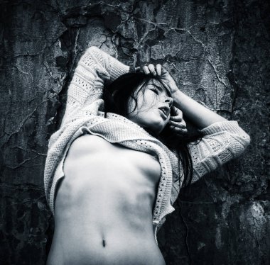 Yaşam tarzı kavramı. Koyu mavi makamı tek renkli görüntüde. Eski beton duvar arka plan karşı bir ceket ile çıplak kadın