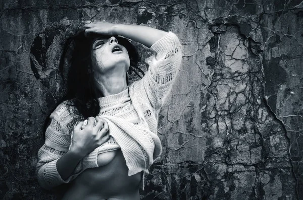 Yaşam tarzı kavramı. Koyu mavi makamı tek renkli görüntüde. Eski beton duvar arka plan karşı bir ceket ile çıplak kadın