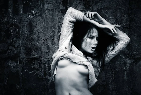 Yaşam tarzı kavramı. Koyu mavi makamı tek renkli görüntüde. Eski beton duvar arka plan karşı bir ceket ile çıplak kadın