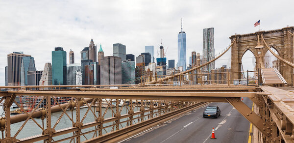 NEW YORK, USA - Apr 29, 2016: Brooklyn Bridge and Financial District in New York City. Rush hour traffic of cars on the Brooklyn Bridge vehicle road