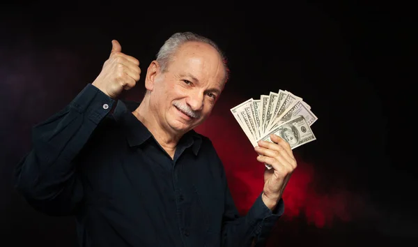 上級紳士お金のスタックを保持します 興奮して古いビジネスマンの肖像画 濃い赤の背景にドル紙幣を持って幸せな老人 — ストック写真