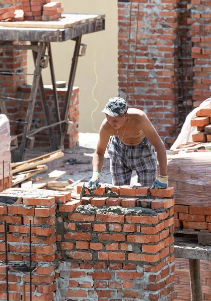 Handwerker baut ein Backsteinhaus — Stockfoto