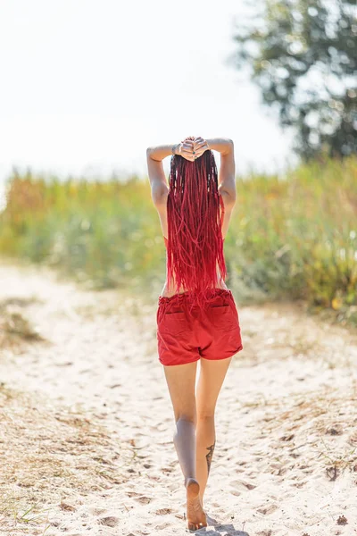 Menina em um maiô vermelho na praia — Fotografia de Stock