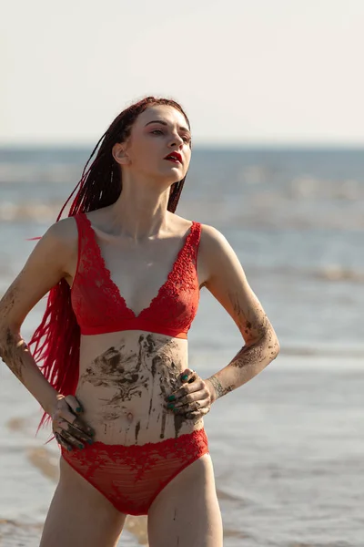 Meisje in een rode badpak op het strand — Stockfoto