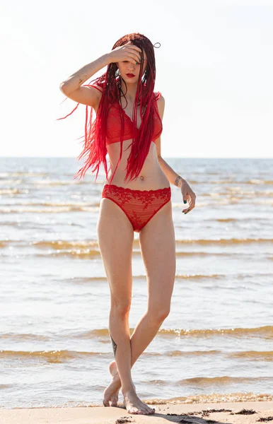 Meisje in een rode badpak op het strand — Stockfoto