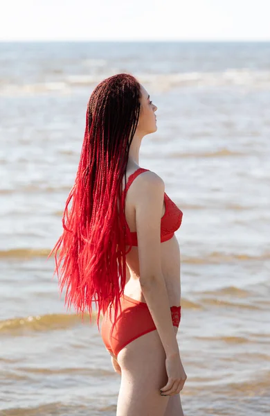 Meisje in een rode badpak op het strand — Stockfoto