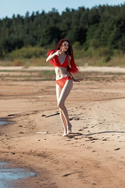 Chica en un traje de baño rojo en la playa —  Fotos de Stock
