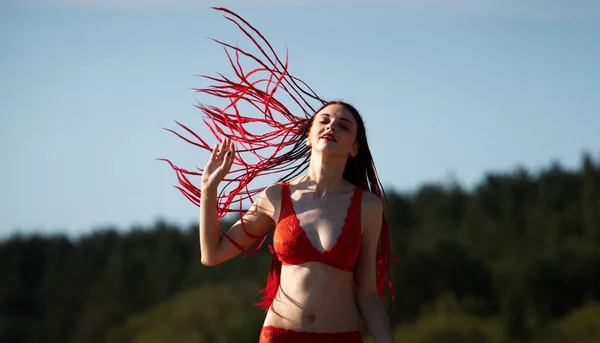 Flicka i en röd baddräkt på stranden — Stockfoto