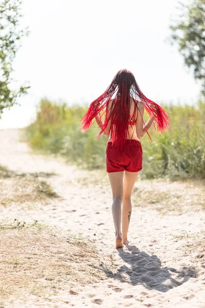 Meisje in een rode badpak op het strand — Stockfoto