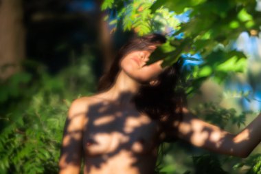 orman arka planda güneş ışığında çıplak kadın