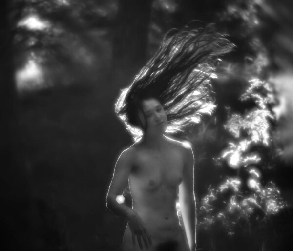 nude woman in sun light on the forest background