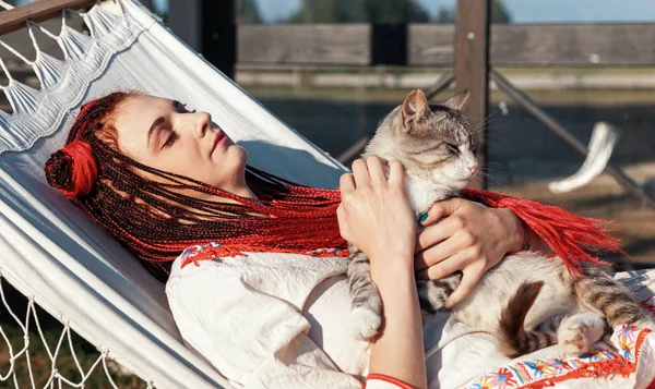 Молода жінка грає з кішкою — стокове фото