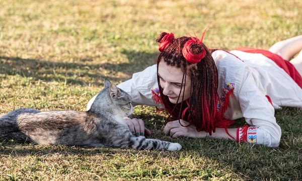Young woman playing with cat