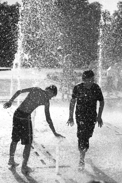 Niños jugando en una fuente de agua —  Fotos de Stock