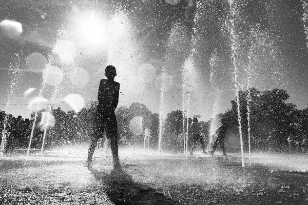 Niños jugando en una fuente de agua — Foto de Stock