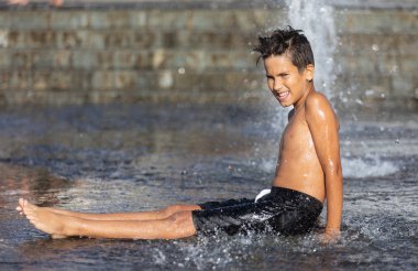 Su fıskiyesinde oynayan mutlu çocuklar