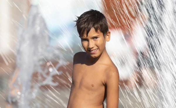 Niños felices jugando en una fuente de agua —  Fotos de Stock