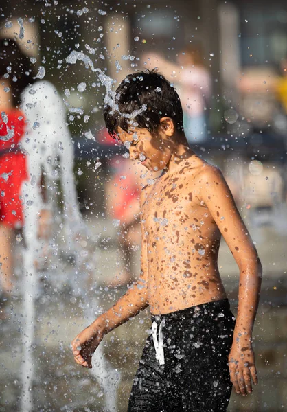 水の噴水で遊ぶ幸せな子供たち — ストック写真