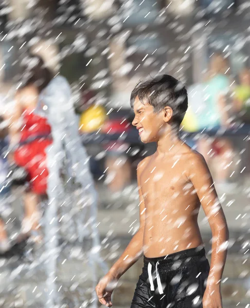 Niños felices jugando en una fuente de agua —  Fotos de Stock