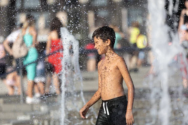 Niños felices jugando en una fuente de agua —  Fotos de Stock