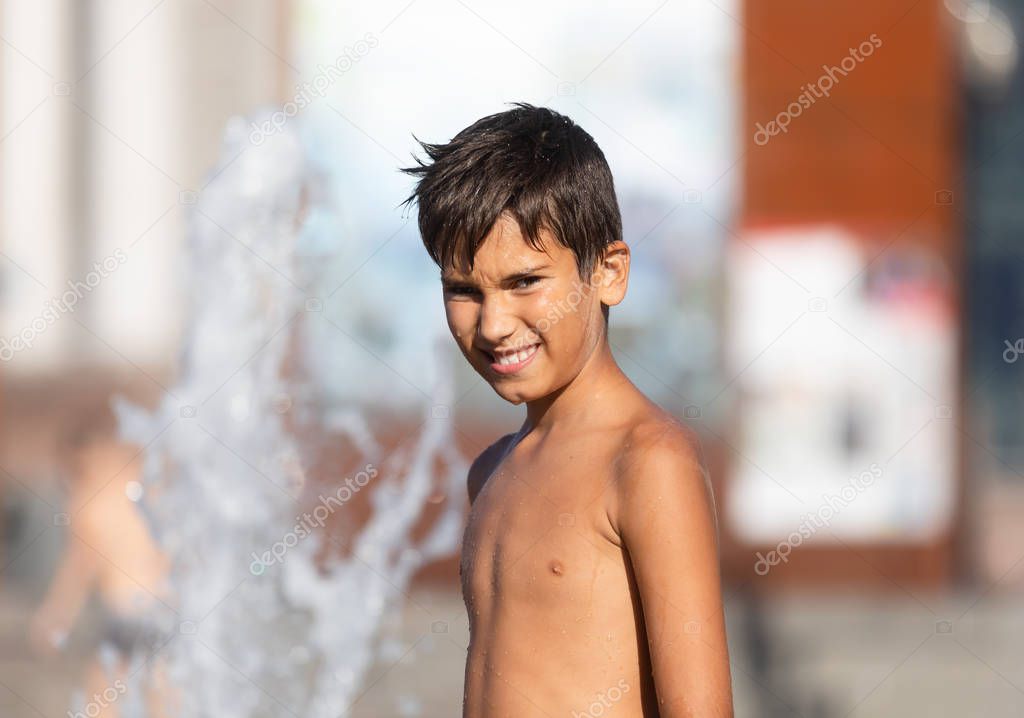 Happy children playing in a water fountain