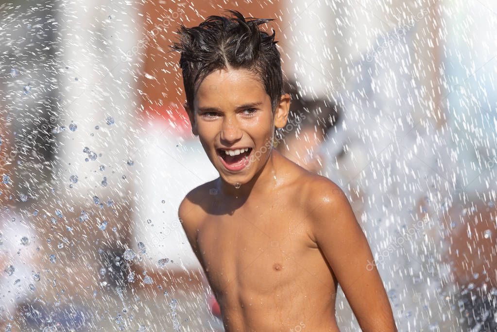 Happy children playing in a water fountain