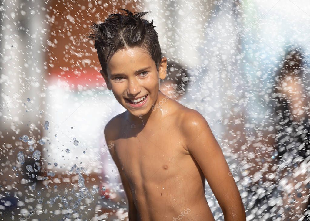 Happy children playing in a water fountain