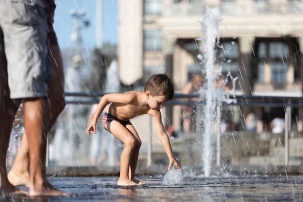 Crianças felizes brincando em uma fonte de água — Fotografia de Stock