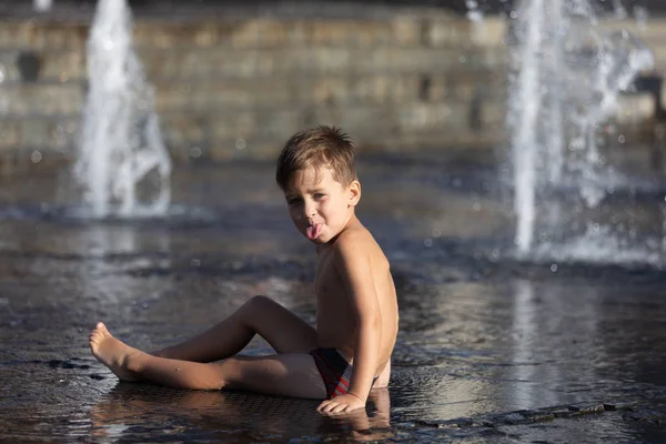 Niños felices jugando en una fuente de agua —  Fotos de Stock