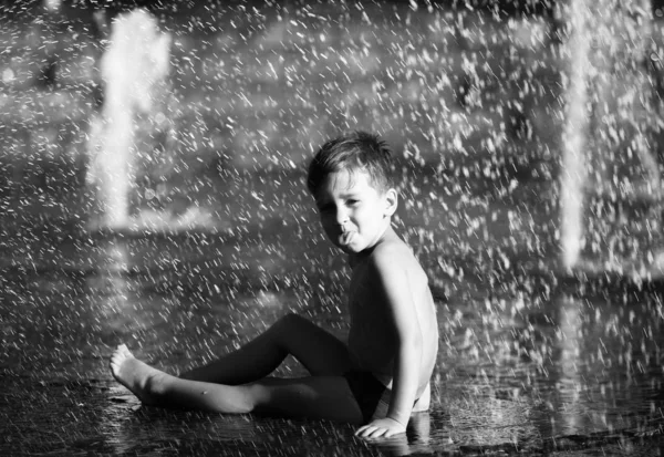 Niños felices jugando en una fuente de agua —  Fotos de Stock