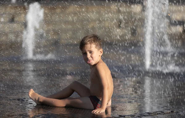 Bambini felici che giocano in una fontana d'acqua — Foto Stock