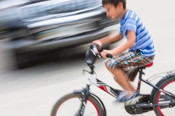 Vaarallinen kaupunkiliikenteen tilanne pojan kanssa polkupyörällä — kuvapankkivalokuva