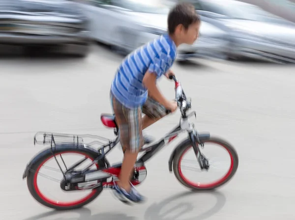 Dangerous city traffic situation with a boy on bicycle — Stock Photo, Image