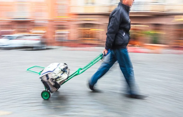 Man bär vagnen med påse — Stockfoto