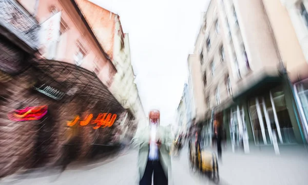 Äldre gråhåriga man med en mobiltelefon — Stockfoto