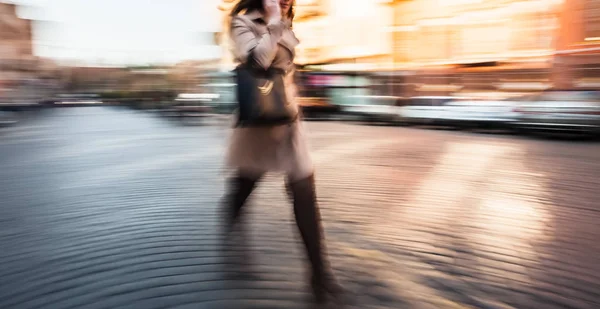 Ung kvinna pratar på en mobiltelefon bråttom — Stockfoto