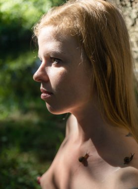 Vücudunda salyangoz olan çıplak bir kadın.