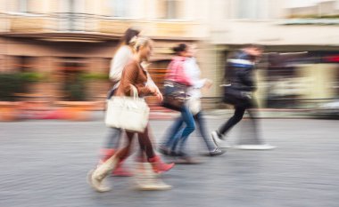 Bir grup genç insan cadde boyunca ilerliyorlar. Kasıtlı hareket bulanıklığı