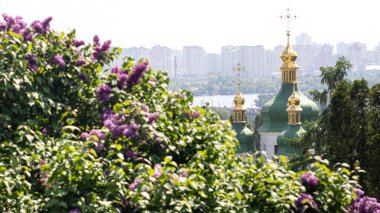 Ukrayna 'nın başkenti Kyiv' deki Hryshko Ulusal Botanik Bahçesinde Vydubychi Manastırı, Dnipro Nehri ve leylak çiçekleri görülüyor. Geniş 16: 9 fotoğrafı.