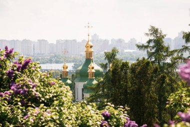 Ukrayna, Kyiv 'deki Hryshko Ulusal Botanik Bahçesi' nde Vydubychi Manastırı, Dnipro Nehri ve leylak çiçekleri görülüyor.