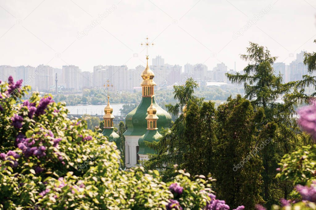 View of Vydubychi Monastery, Dnipro river and lilac flowers in Hryshko National Botanical Garden in Kyiv, Ukraine