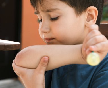 Mutlu çocukluk kavramı. Lolipop yiyen küçük çocuğu kes ve elindeki çiziğe bak.