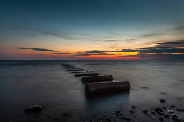 Old concrete pier at sea in the evening during sunset