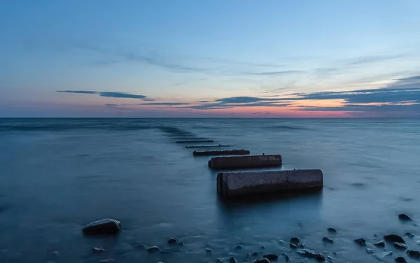 Old concrete pier at sea in the evening during sunset