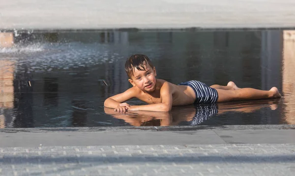 Ein Kleiner Junge Spielt Einem Wasserbrunnen Und Genießt Die Kühlen — Stockfoto